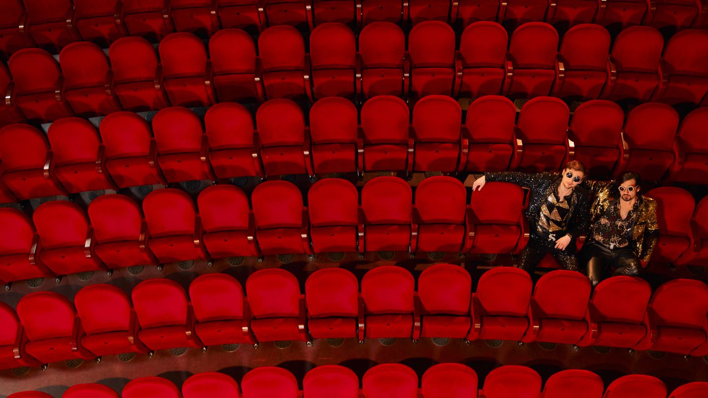 Siegfried und Joy im Zuschauersaal auf roten Stühlen