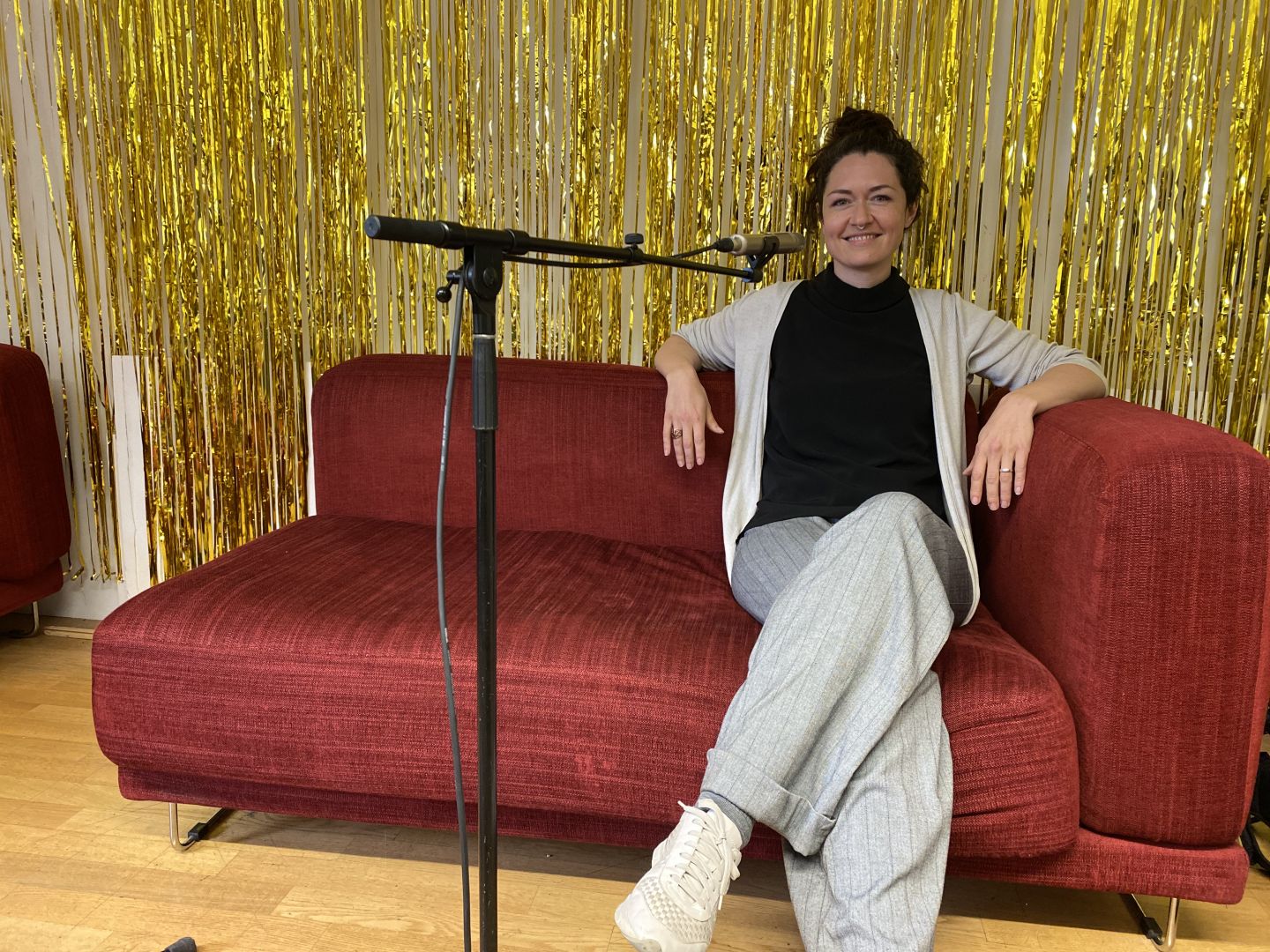 Lisa Müller-Gahr sitzt auf einem roten Sofa