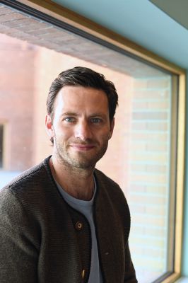 Jonathan Müller (c) Gabriela Neeb Das Foto zeigt ein Portrait von Jonathan Müller im Volkstheater vor großem Fenster