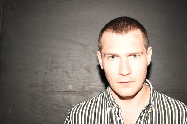 Portrait von Lukas Darnstädt vor einer dunklen Wand