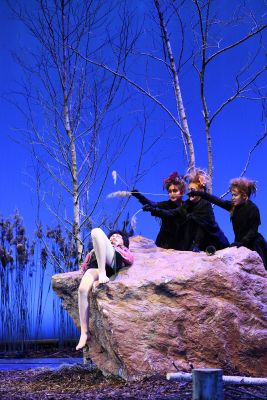 Krippenspiel (c) Gabriela Neeb Ein Darsteller liegt schlafend auf einen  Stein, während drei andere mit Fahnwedeln auf ihn deuten.