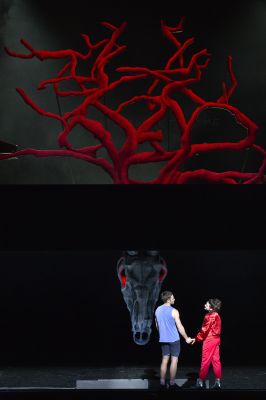 Die Rolle von Jonathan Müller &amp; Nina Steils stehen vor einem Baum mit roten Ästen, halten Händchen und schauen sich an.