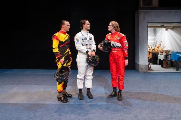 Die Rollen vonSteffen Link, Jan Meeno Jürgens, Liv Stapelfeldt stehen in Motorradkleidung nebeneinader. Die Rolle von  Liv Stapelfeldt spricht, während die anderen beiden sie anschauen.