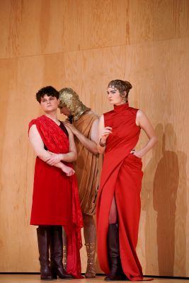 Die Rollen von Cedric Stern, Nils Karsten und Liv Stapelfeldt stehen auf der Bühne. Cedric Sterns und Liv Stapelfeldts Rollen in roten Kleidern schauen nach vorne, während die Rolle von Nils Karsten in goldener Kleidung hinter den Beiden steht und nach unten Blickt.