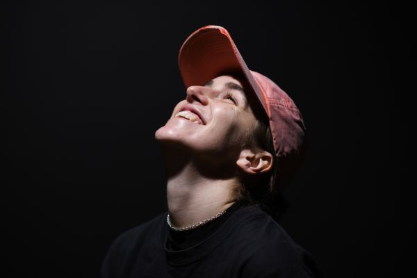 Portrait von Ruth Bohsung vor einer schwarzen Wand. Sie schaut lachend in Richtung Decke.