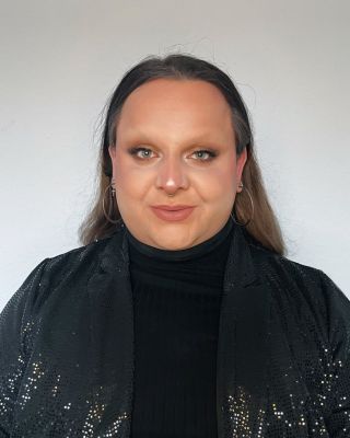 Zu sehen ist ein Portrait von Timur vor einem hellen Hintergrund.