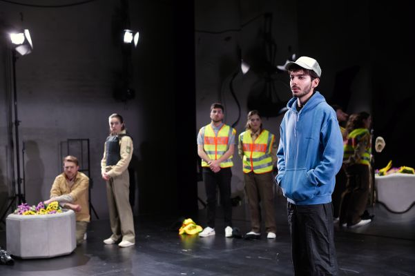 Vier Spieler*innen in Polizeiuniform blicken auf Enes Şahin.