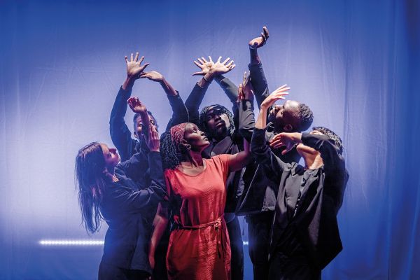 Das Ensemble von Theater Grenzenlos steht auf der Bühne und streckt die Arme in die Lüfte.