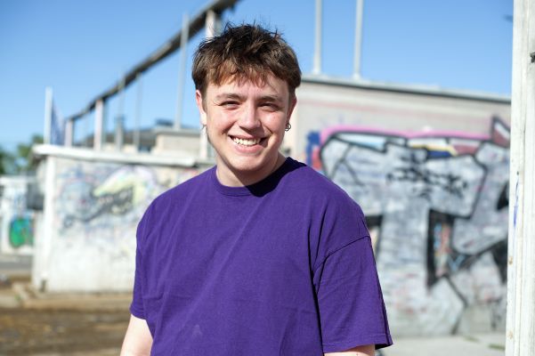 Lasse Stadelmann lachend vor Graffiti