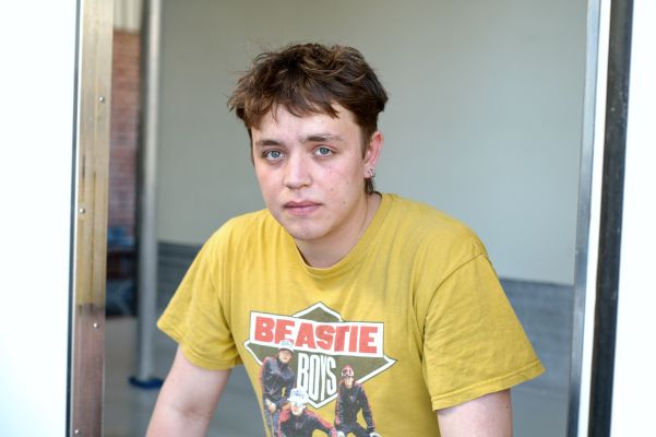 Lasse Stadelmann blickt aus einem Fenster und trägt ein gelbes Beastie Boys-TShirt