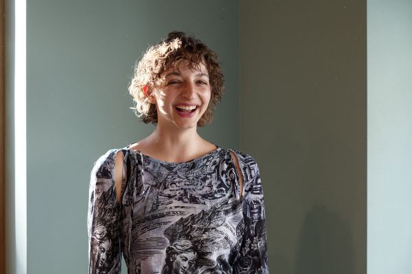 Marlene Markt lachend vor einer grünen Wand