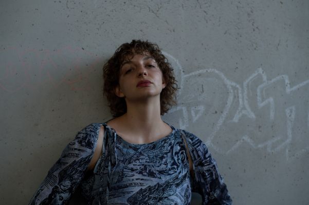 Marlene Markt lehnt an einer Betonwand, den Kopf in den Nacken gelegt