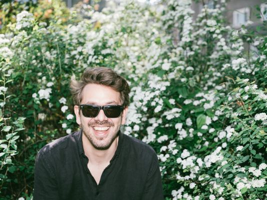 Lemo (c) Ingo Pertramer Lemo lachend mit Sonnenbrille vor einem Holunderstrauch