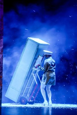 Genet Zegay (c) Arno Declair Ein Postbote schiebt ein Menschengroßes Paket durch den Schnee.