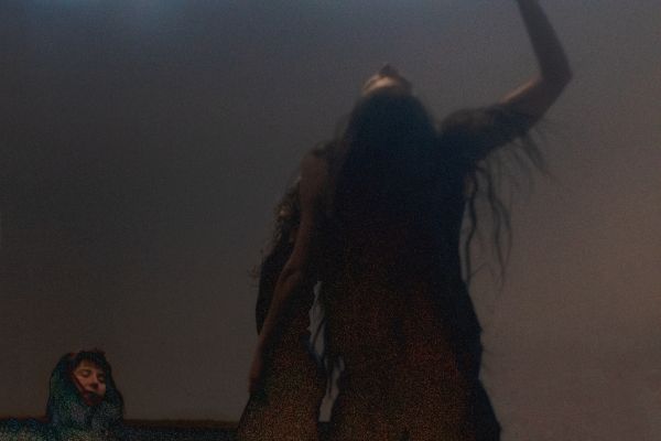 Zwei Frauen die tanzen. Die Umgebung ist nebelig.