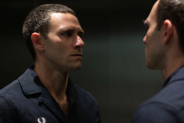 Portraitfoto von Jonathan Müller, wie er in einen Spiegel blickt