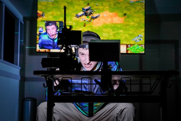 Ein Schauspieler spielt ein Videospiel und filmt das mit einer Kamera.