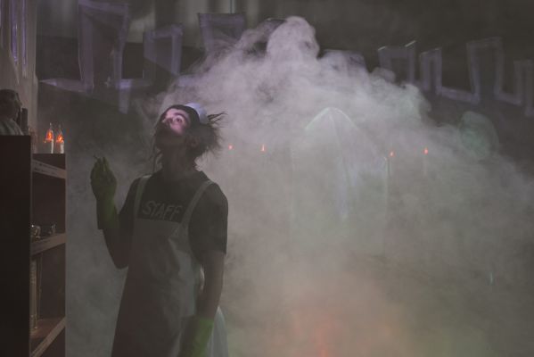 Ein Hausmädchen steht im Nebel und raucht.