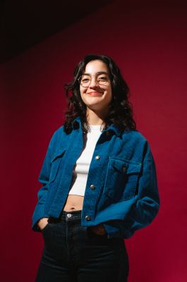 Ana Lucia vor einem weinroten Hintergrund
