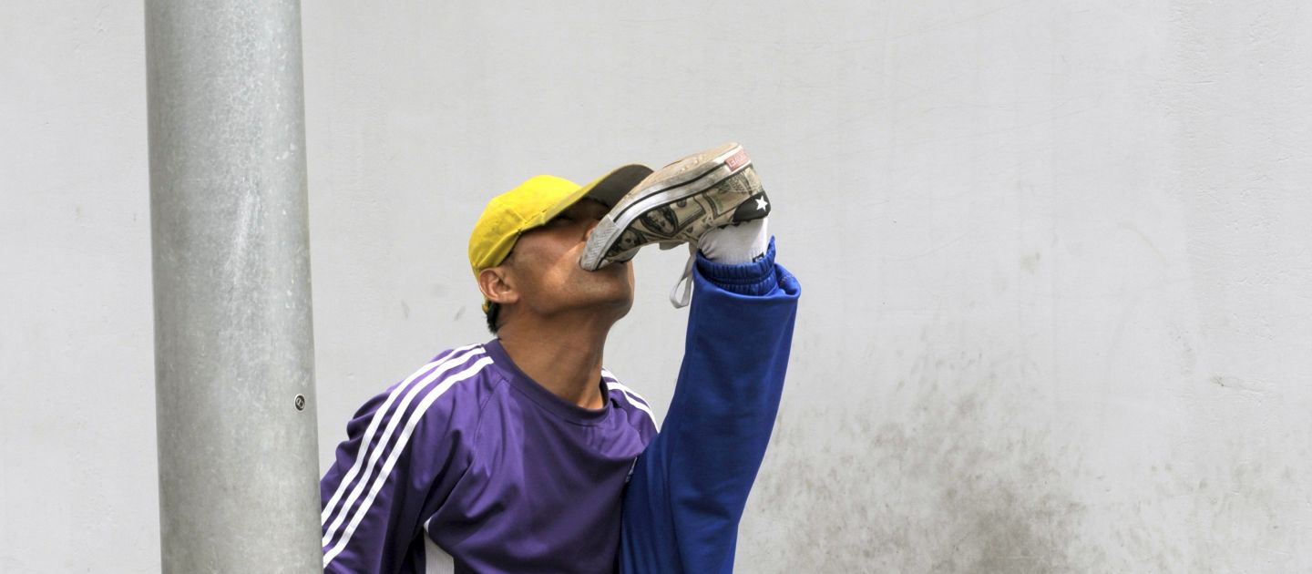 Ein Mann im Trainingsanzug, der sich in den Schuh beist