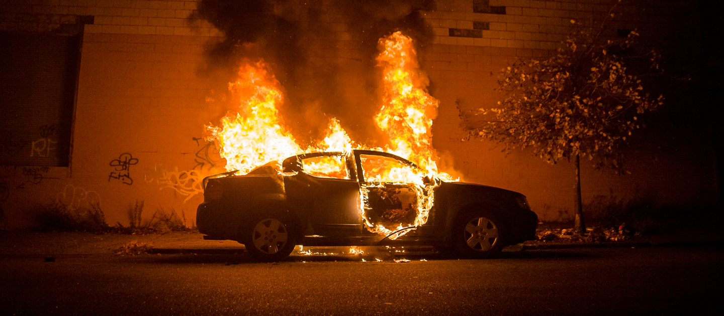 Ein brennendes Auto am Straßenrand