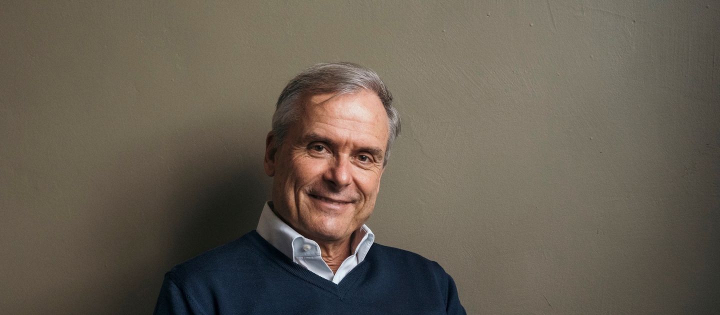 Axel Hacke Ein Portraitfoto von Axel Hacke. Er sitzt und schreibt in ein Notizheft.