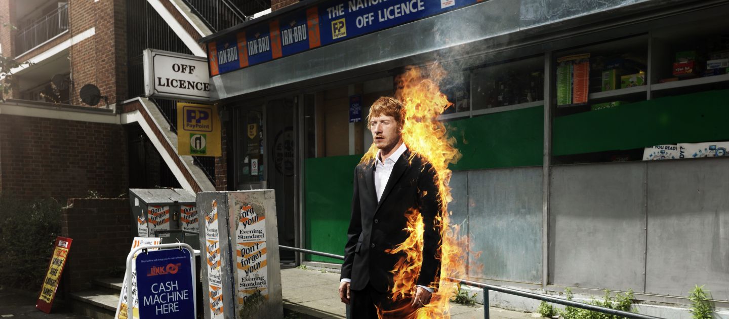 Das Plakatmotiv von Fabian oder: der Gang vor die Hunde zeigt einen brennenden Mann im Anzug vor einer Lotterie.