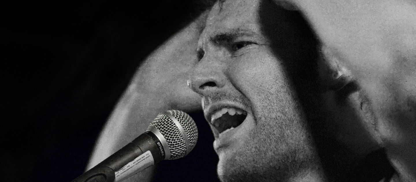 Best of Poetry Slam Ein Slammer auf der Bühne in schwarz-weiß