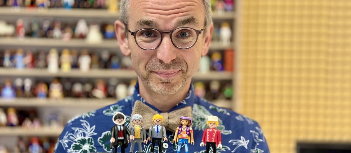 Michael Sommer hält fünf Playmobilfiguren auf einem Tablet.