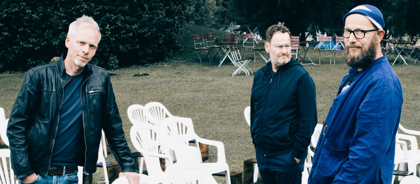 Das Trio der Bananafishbones auf einer Wiese umgeben von Plastikstühlen.