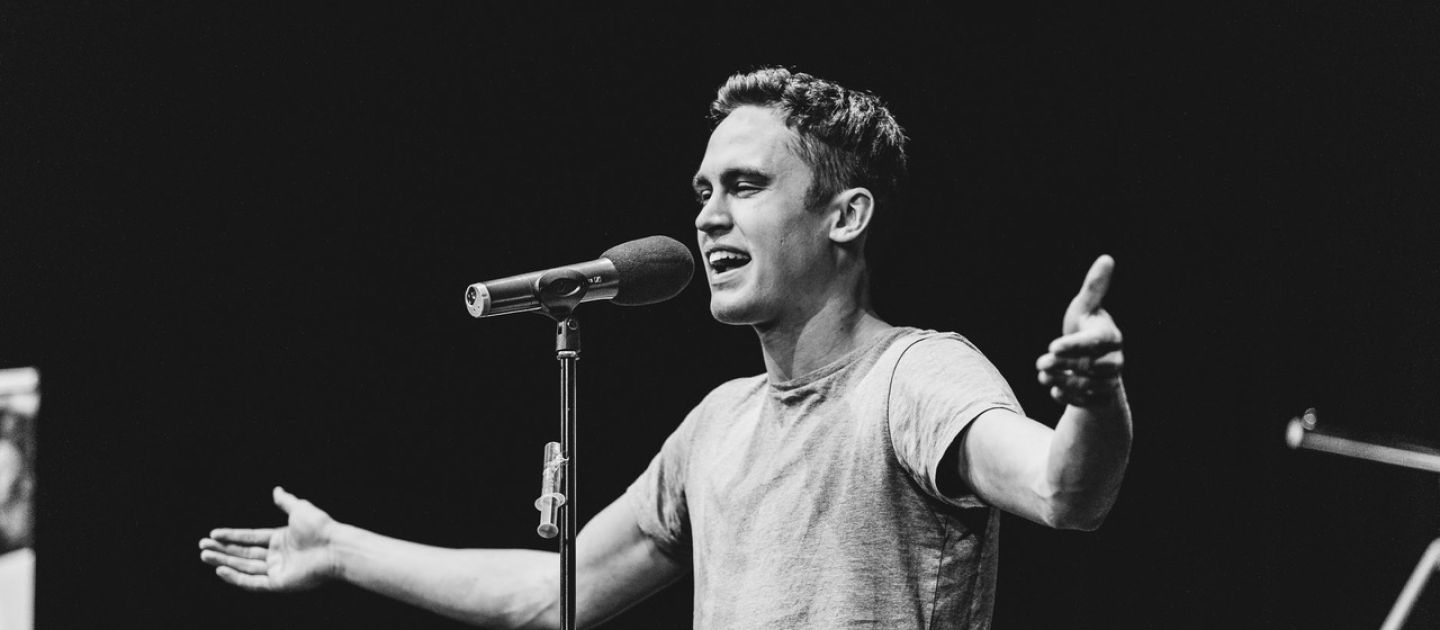 Emil Kaschka (c) Celine Vögel Emil Kaschka trägt an einem Mikrofon seinen Poetry Slam vor