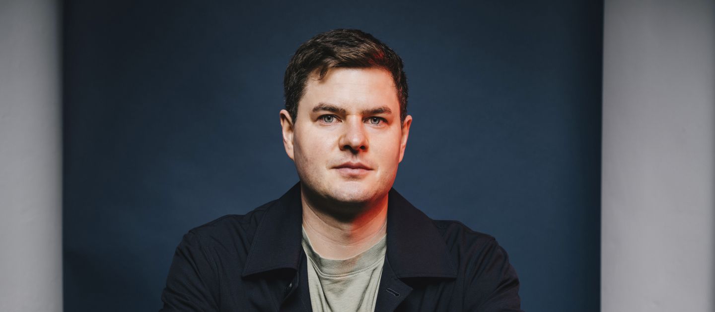 Moritz Hürtgen sitzt mit verschränkten Armen am Tisch.