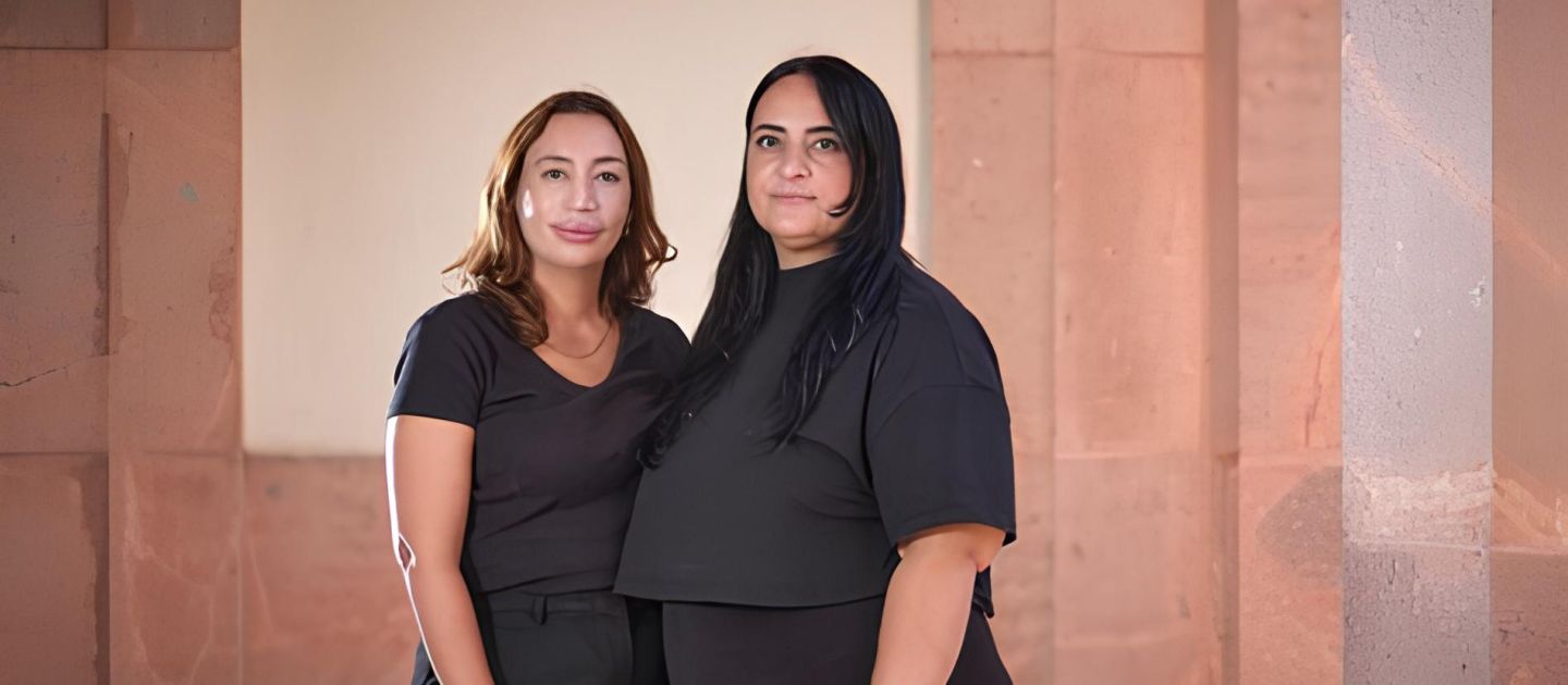 Zwei Frauen stehen und schauen in die Kamera