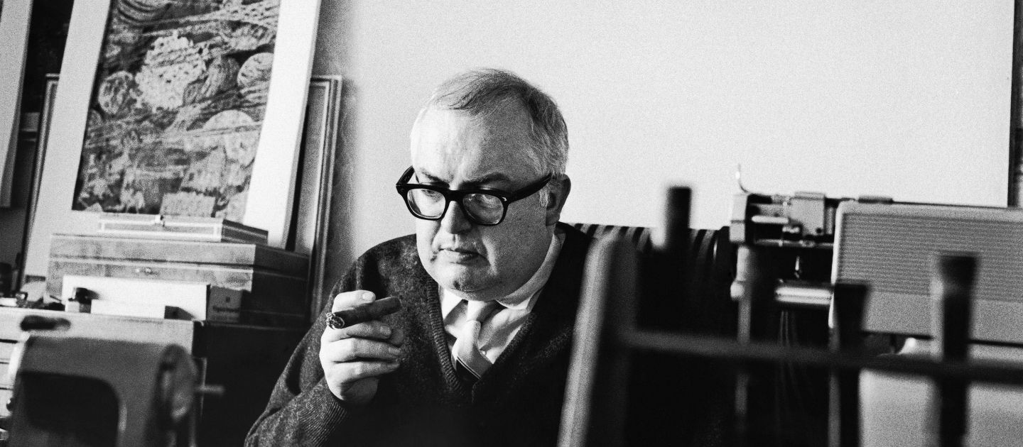 Friedrich Dürrenmatt mit Zigarre am Schreibtisch