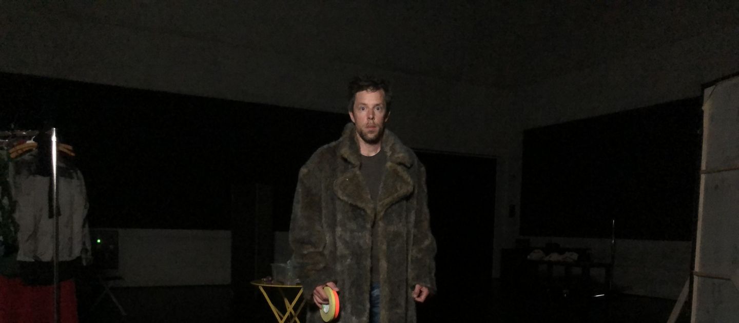 Das Bild zeigt Sebastian Pircher in einem großen Mantel auf einer Probe.