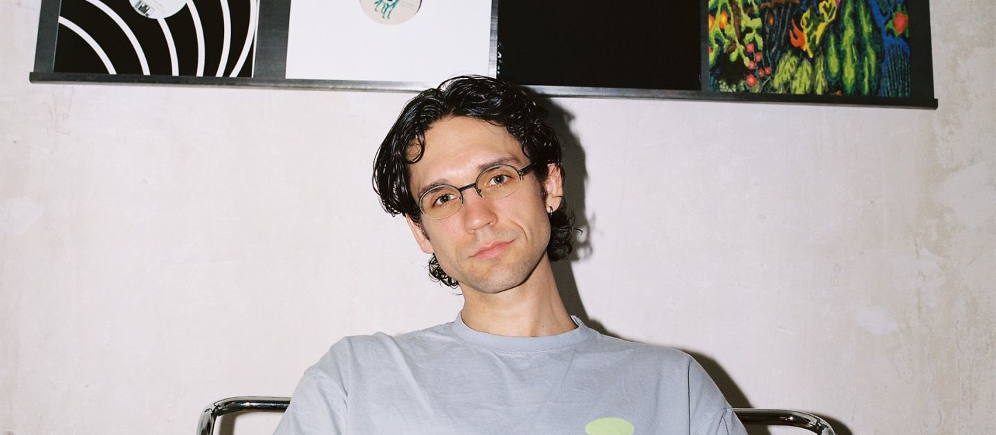 Matthias Schubert (c) Laura Czyzewski Matthias Schubert sitzt vor einer Wand, an der Platten aufgehängt sind.