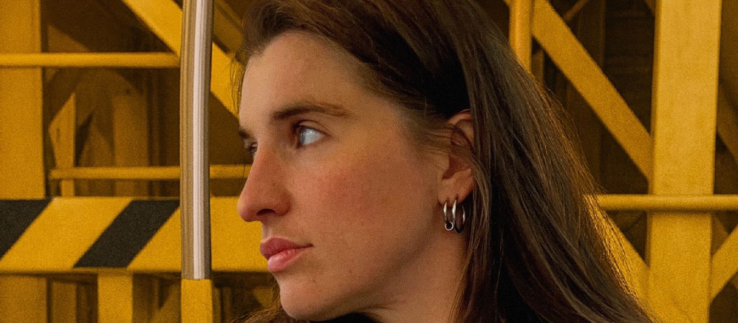 Laura Kirst (c) privat Ein Portraitfoto von Laura Kirst vor einem gelben Gestell.
