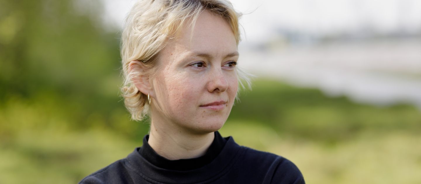 Sophie Glaser steht mit überkreuzten Armen auf einer Wiese.