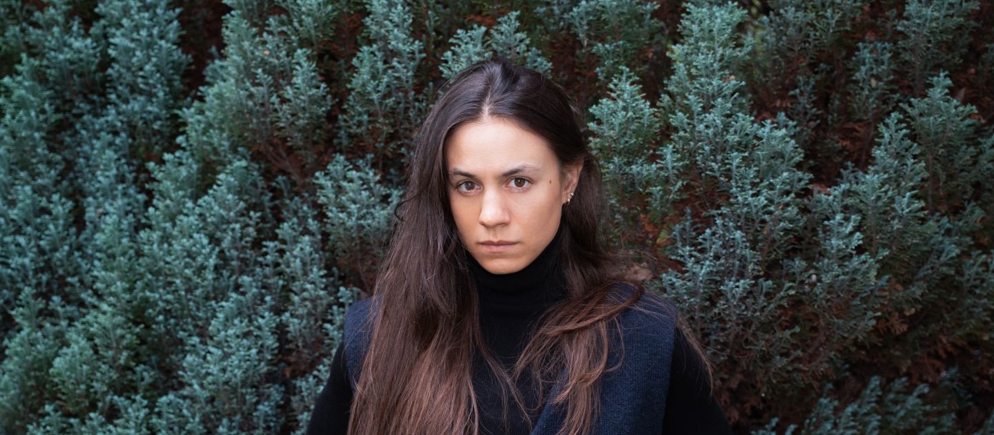 Portraitfoto von Anouk Kesou vor einer Tanne