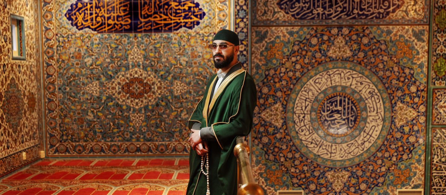 Foto von Liam Monzer Alzafari umgeben von persischen Teppichen.