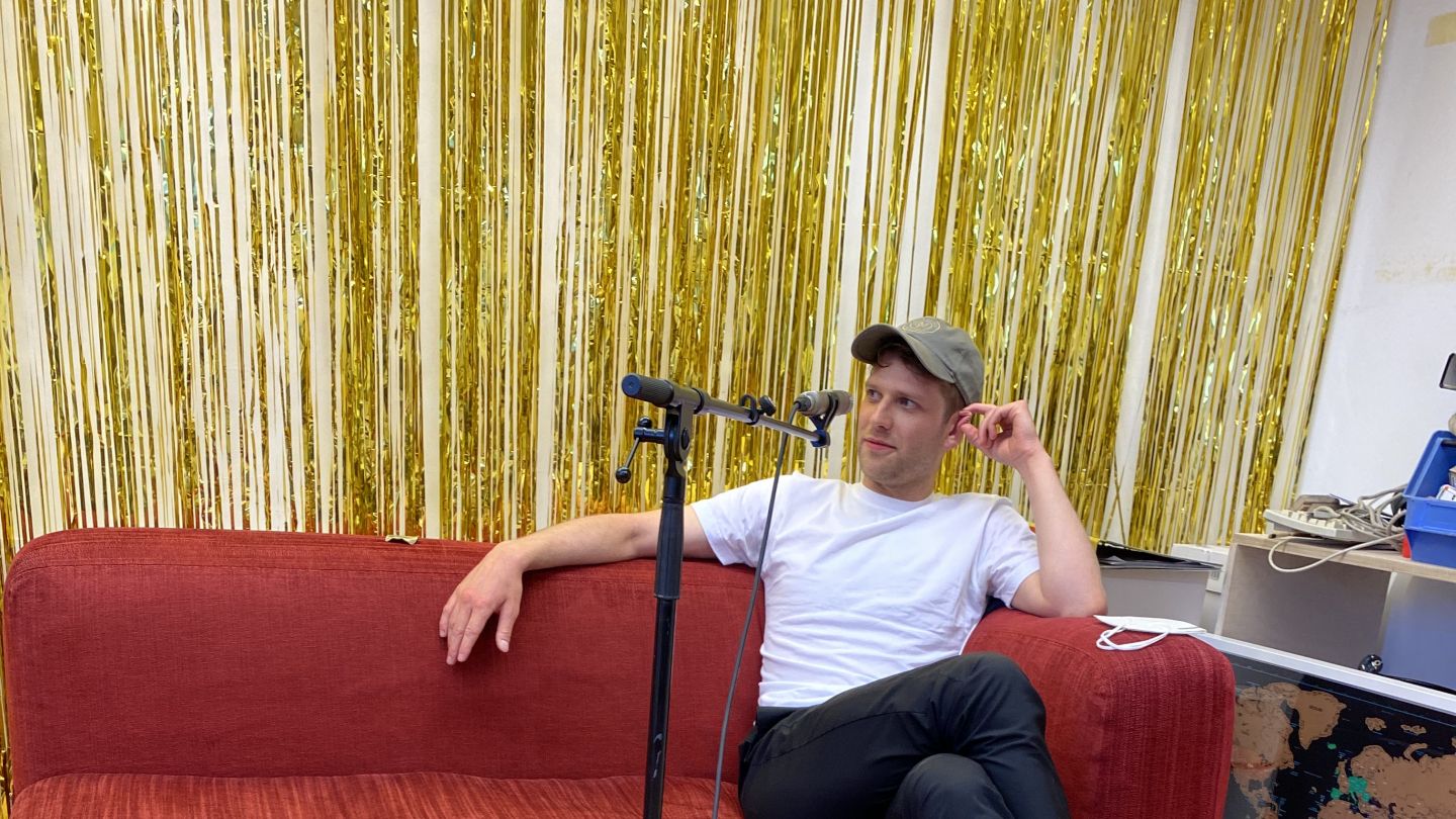 Silas Breiding (c) Jenny von Reiche Silas Breiding sitzt auf einem roten Sofa