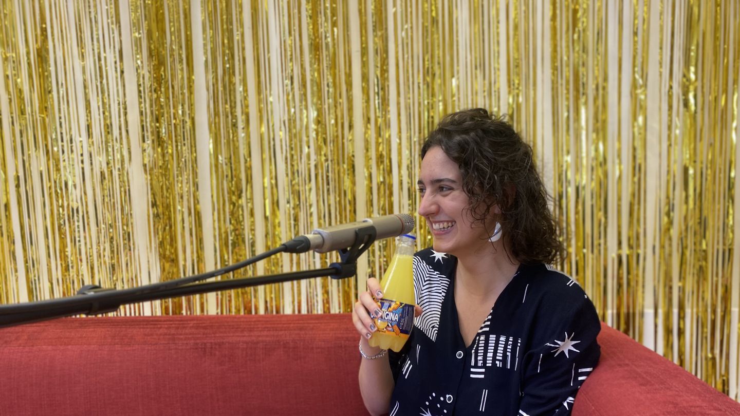 Milena Plach (c) Jenny von Reiche Milena Plach sitzt auf einem roten Sofa und lacht