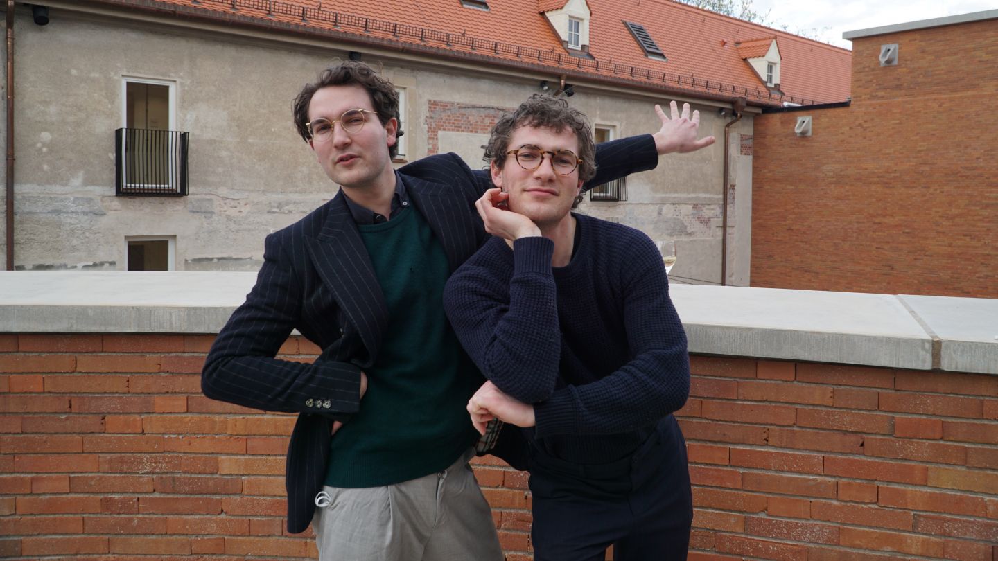 Das Bild zeigt Lukas und Nikolas Darnstädt vor einer Ziegelfassade.