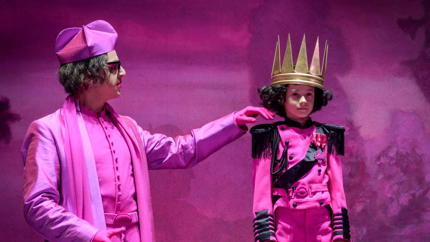 Anton Sommer und Pascal Fligg bei Edward II. (c) Arno Declair Ein in rosa gekleideter Mann streicht einem rosa gekleideten Kind mit einer Krone über die Wange.