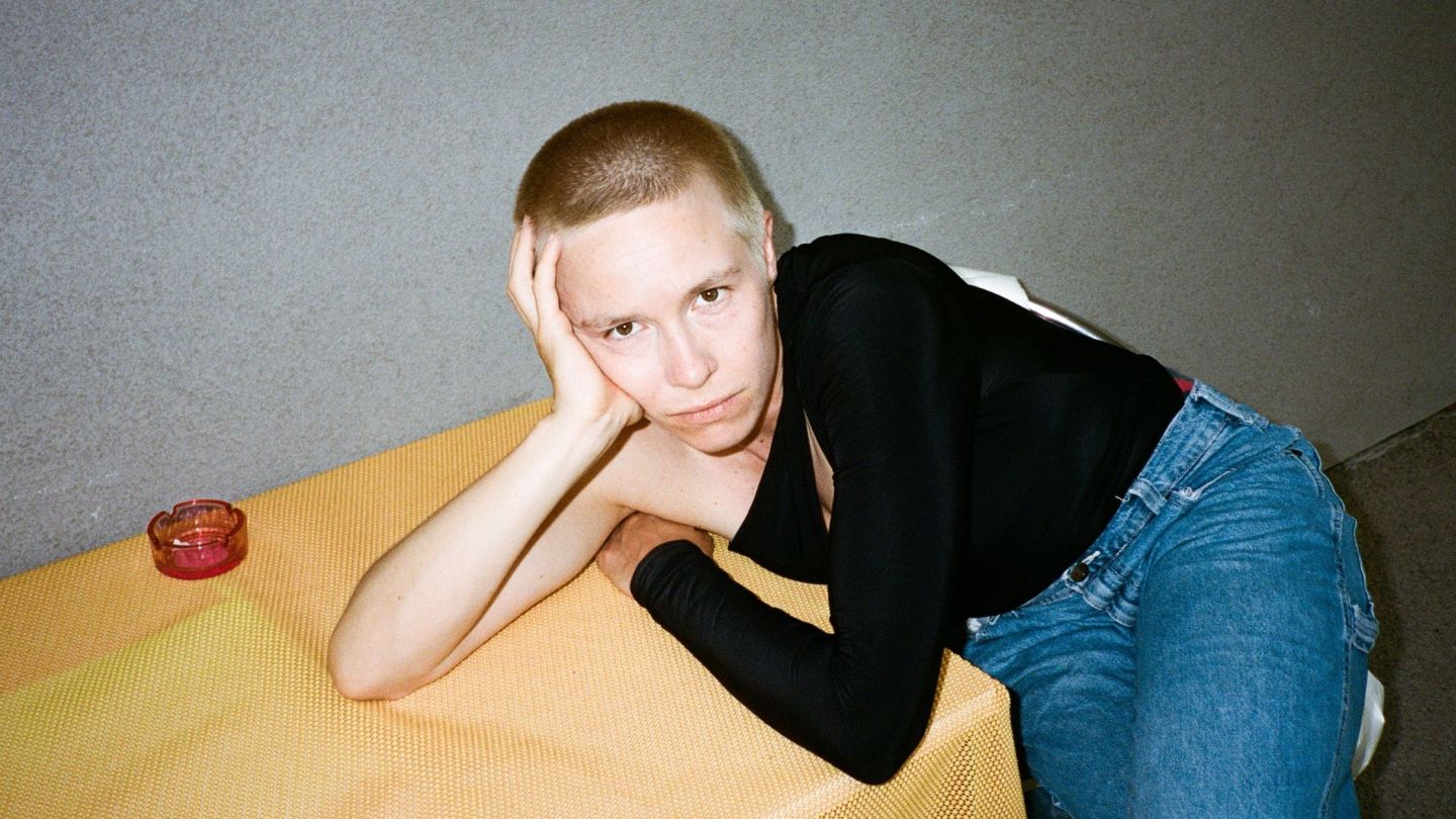 Portraitfoto von Anna Marboe, die ihren Kopf auf einem Tisch aufstützt