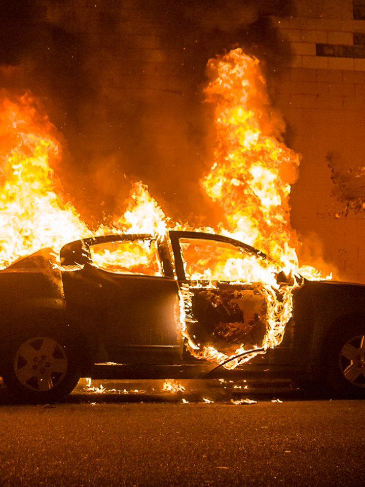 Ein brennendes Auto am Straßenrand