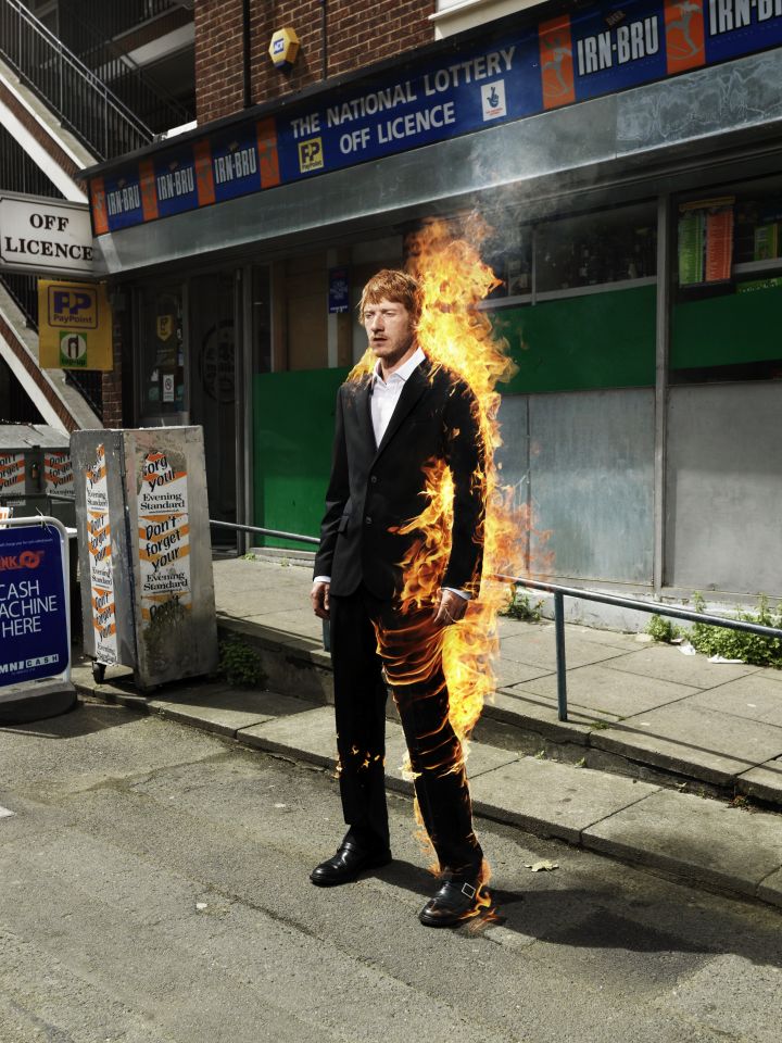 Ein Mann im einem brennenden Anzug steht vor einer Lotterie.
