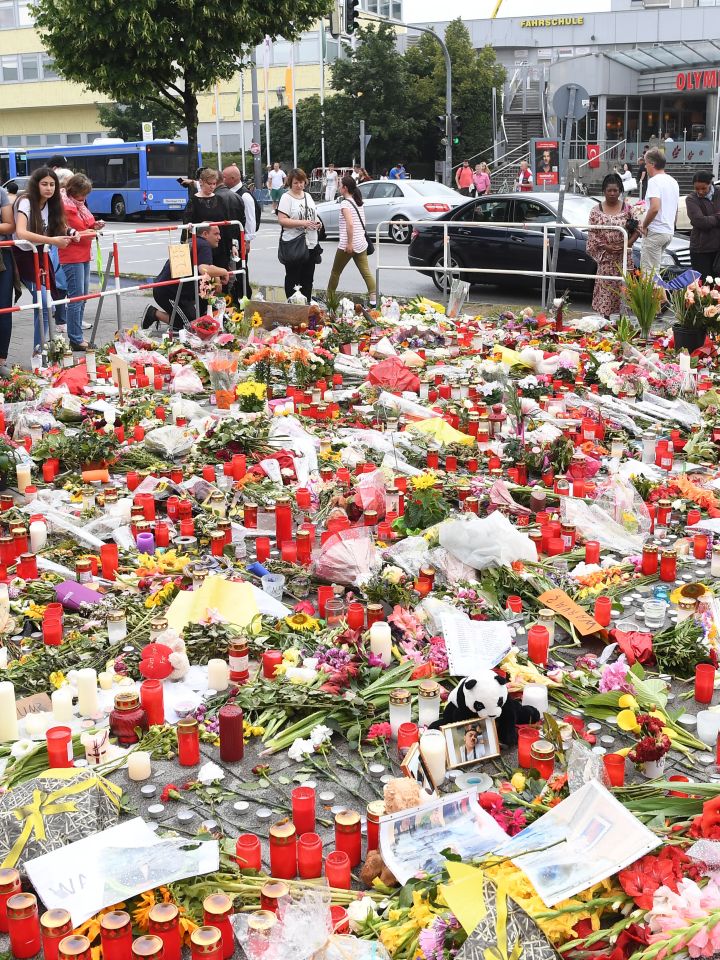 Gedenkort mit niedergelegten Blumen, Bildern, Briefen und Grabkerzen