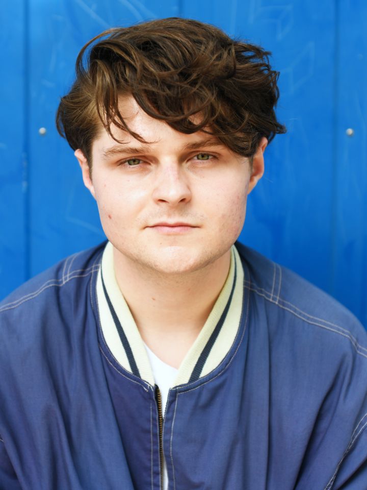 Portrait von Cedric Stern vor einer blauen Wand