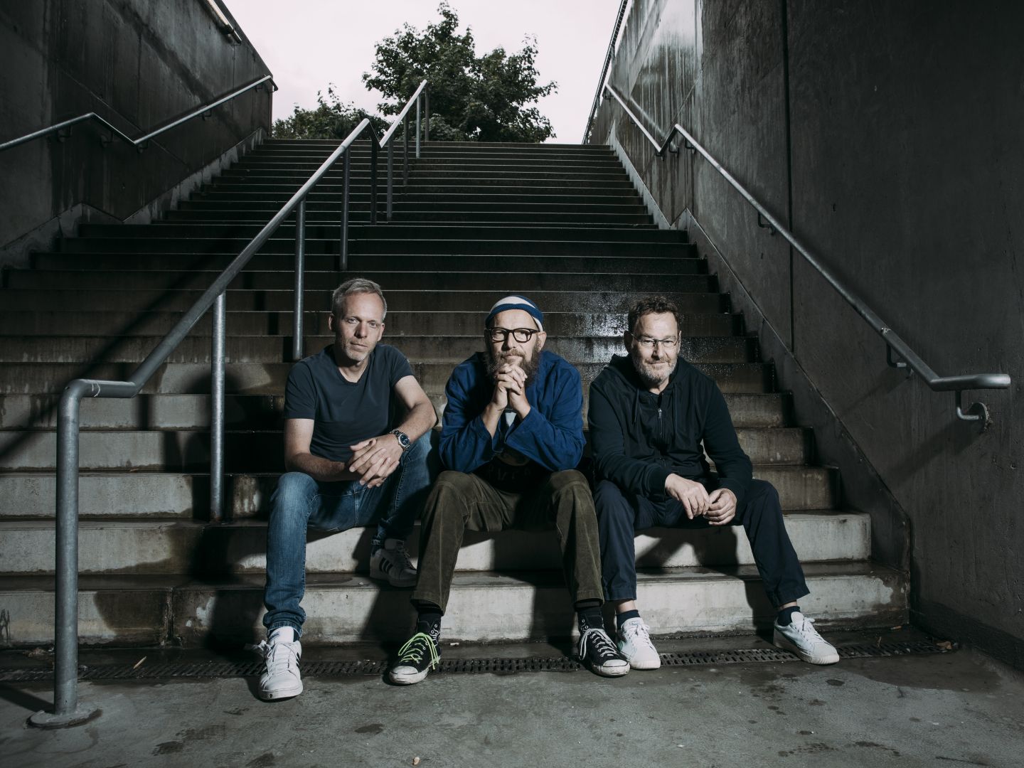 Die drei Musiker der Bananfishbones auf einer Treppe sitzend.